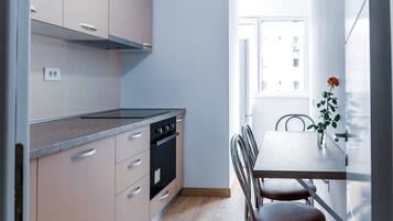 Een koelkast, een microgolfoven, een oven, kookgerei, borden en bestek