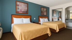 A hotel room with two beds, a large mirror, and artwork on the walls. - Express Inn Gulf Bank (Houston)