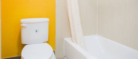 A bathroom with a toilet, a bathtub, and a shower curtain.