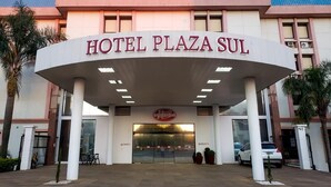 De ingang van Hotel Plaza Sul met een duidelijk bord, een overdekte inkom en een zichtbaar parkeerterrein.