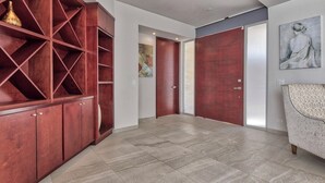 A spacious room with a large wooden cabinet, a sliding door, and a couch. - Gorgeous 3 bed/3bath home in the heart of Ensenada! (Ensenada)