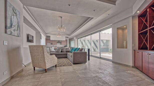 A spacious living area with a large sofa, a patterned armchair, and a chandelier. - Gorgeous 3 bed/3bath home in the heart of Ensenada! (Ensenada)