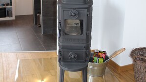 Un foc de llenya a la cuina, amb una barra i una finestra.
