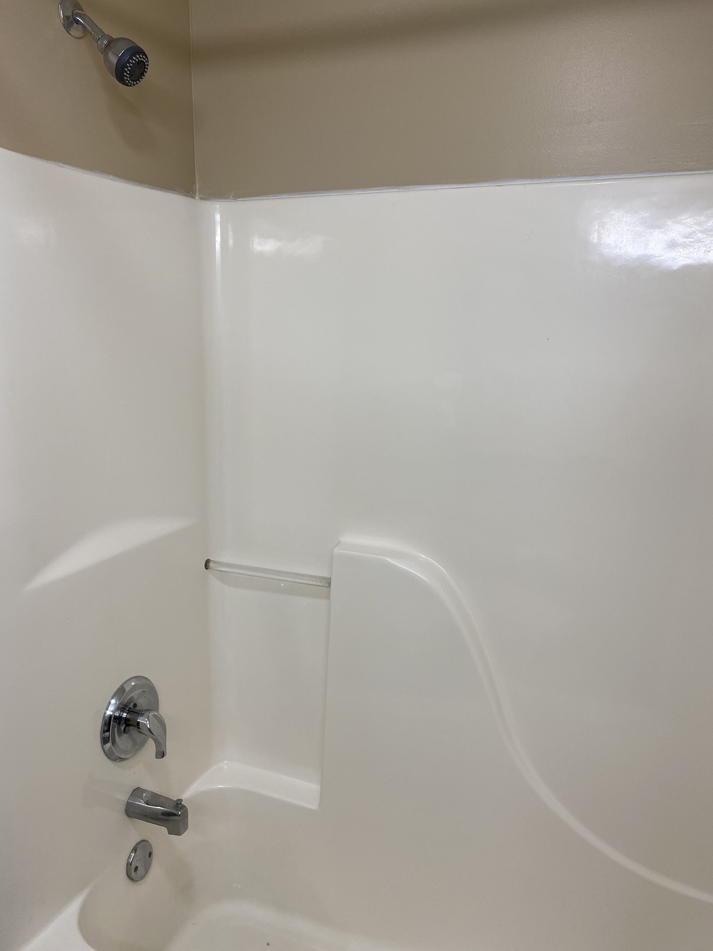 A bathroom with a bathtub, a showerhead, and a faucet.
