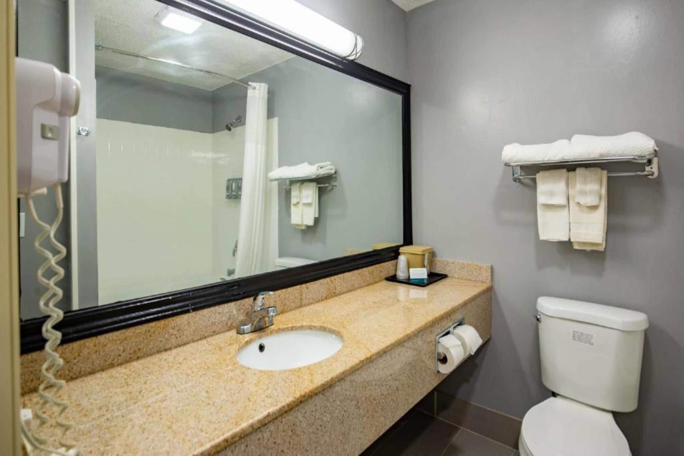 A bathroom with a sink, toilet, and a towel rack.