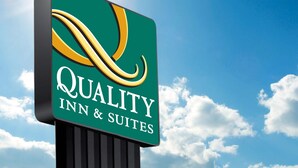 Une enseigne pour le Quality Inn & Suites, avec un logo stylisé.