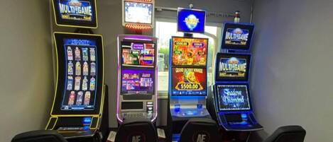 A row of slot machines with the 'Illinois MultiGame' logo, arranged in a row with chairs in front.