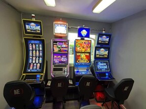 Rivi kolikkopelejä, joissa kaikissa on «Illinois MultiGame» -logo, ja niiden edessä on tuoleja.