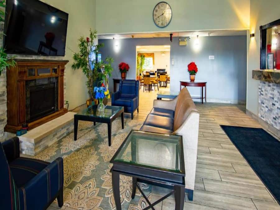 A living room with a fireplace, seating area, and a dining area in the background.