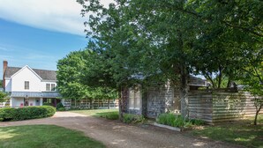 A residential property with a gravel driveway, a wooden fence, and a well-maintained lawn.