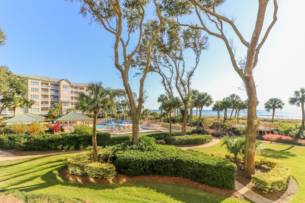A resort with a pool area, palm trees, and a building with multiple balconies.