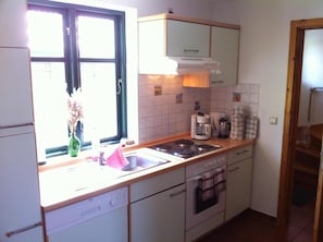 Enjoy cooking in this well-lit kitchen with an oven, sink, and essential appliances.
