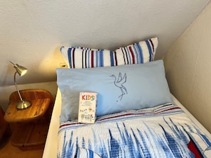 Cozy retreat with a neatly made bed, nightstand, and lamp.