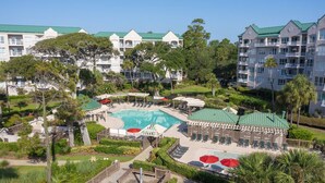 A resort with a central pool, multiple guest rooms, and lush landscaping. - Three Bedroom Oceanfront Property with Views of the Ocean! (Hilton Head)