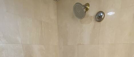 Un baño moderno con una bañera independiente, un cabezal de ducha manual y un grifo de pared.