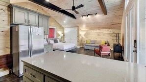 A modern kitchen with a large island, a refrigerator, and wooden ceiling beams. - Chic SoCo Studio | Balcony + Walkable Austin (Austin)