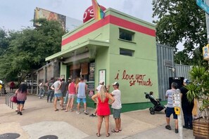 A building with a green facade and a red stripe, featuring a sign that says "i love you so much."
