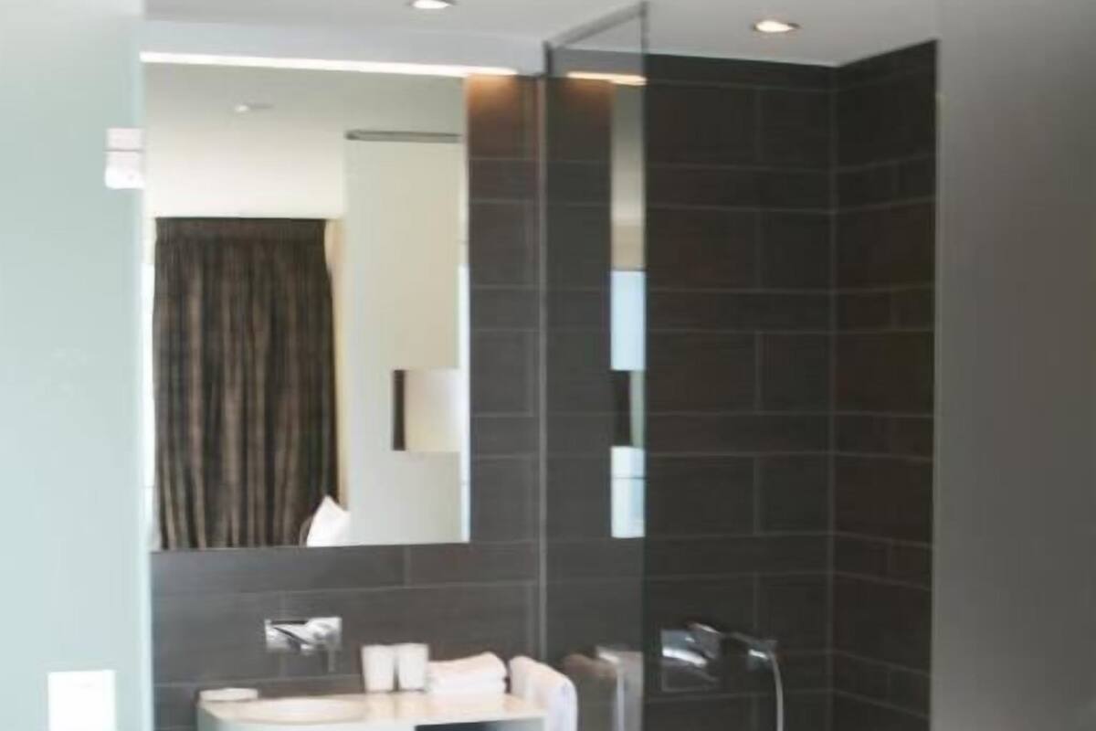 Ein modernes Badezimmer mit Dusche, Waschbecken und Spiegel.