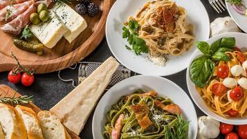 A variety of dishes including pasta, cheese, and meats, suggesting a meal setting.