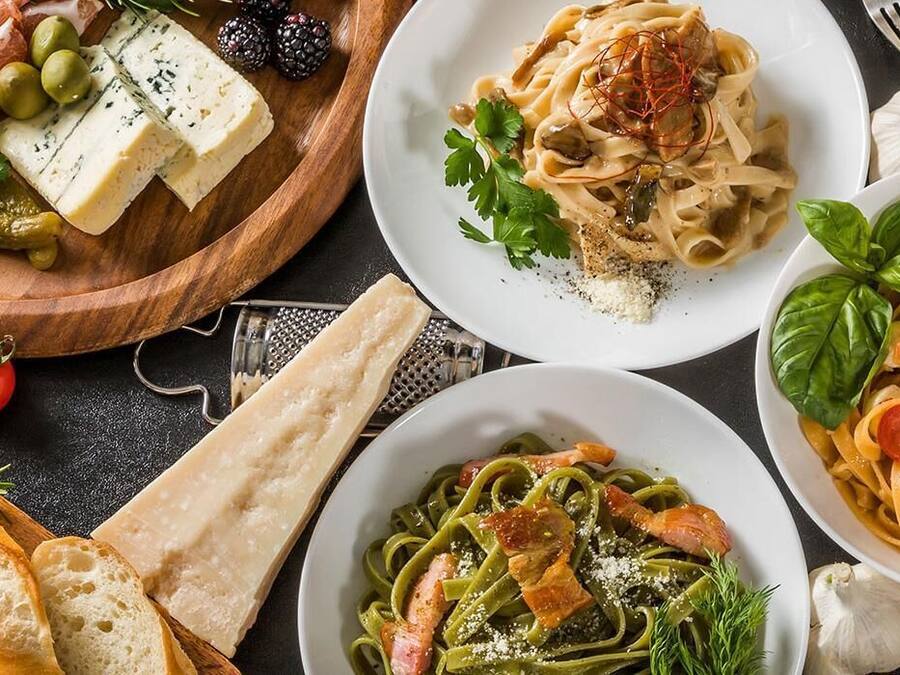 A variety of dishes including pasta, cheese, and meats, suggesting a meal setting.
