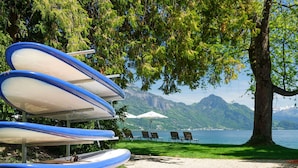 Zona de playa con sillas de descanso y tablas de surf.