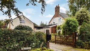 A residential property with a brick house, a wooden gate, and a sign reading "Brackens."