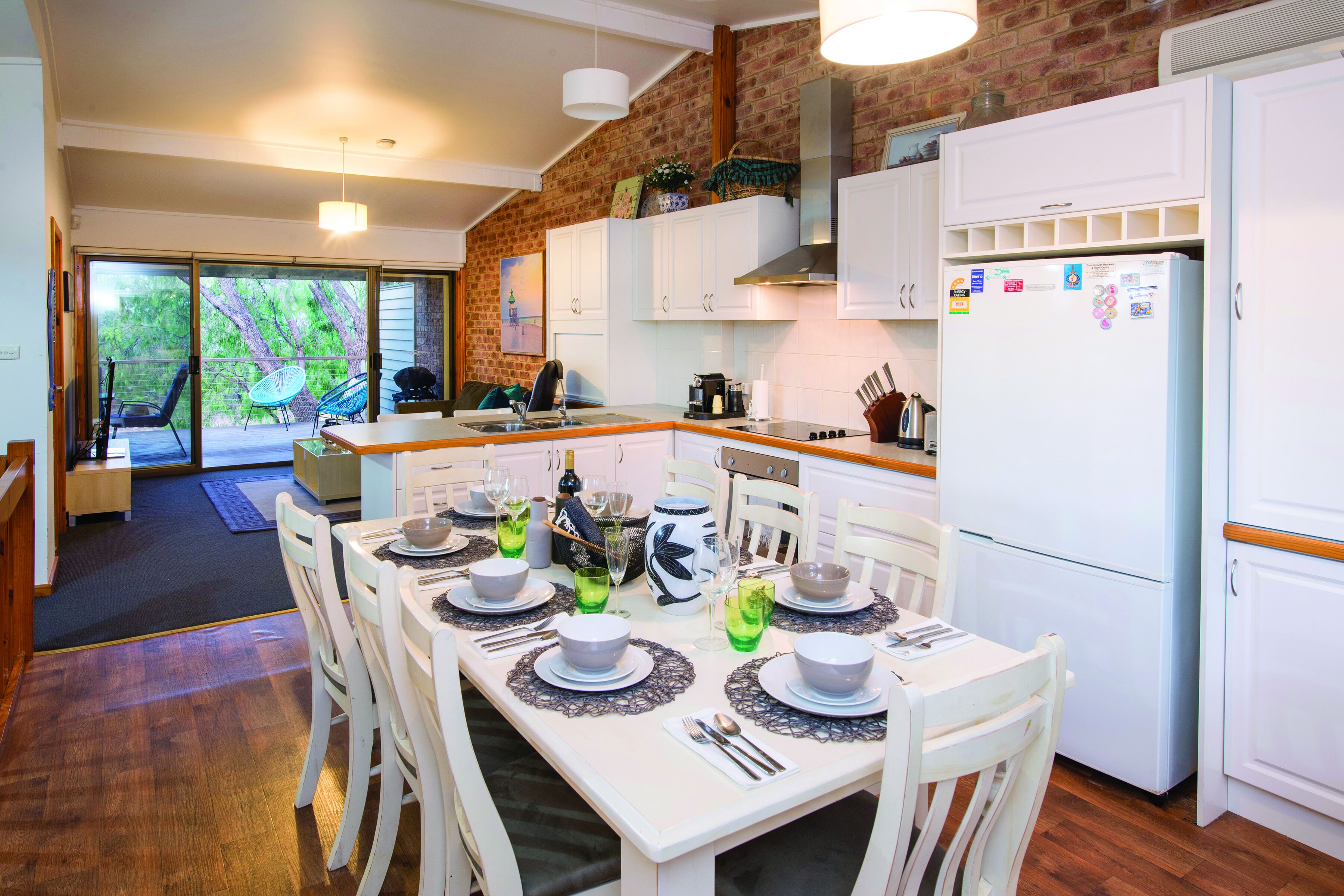 A modern kitchen with white cabinets, a built-in stove, and a refrigerator.