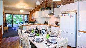 A modern kitchen with white cabinets, a built-in stove, and a refrigerator. - Fantastic Beach House on Quindalup Strip (Quindalup)