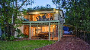 A two-story house with a covered patio, a dining area, and a garage. - Fantastic Beach House on Quindalup Strip (Quindalup)