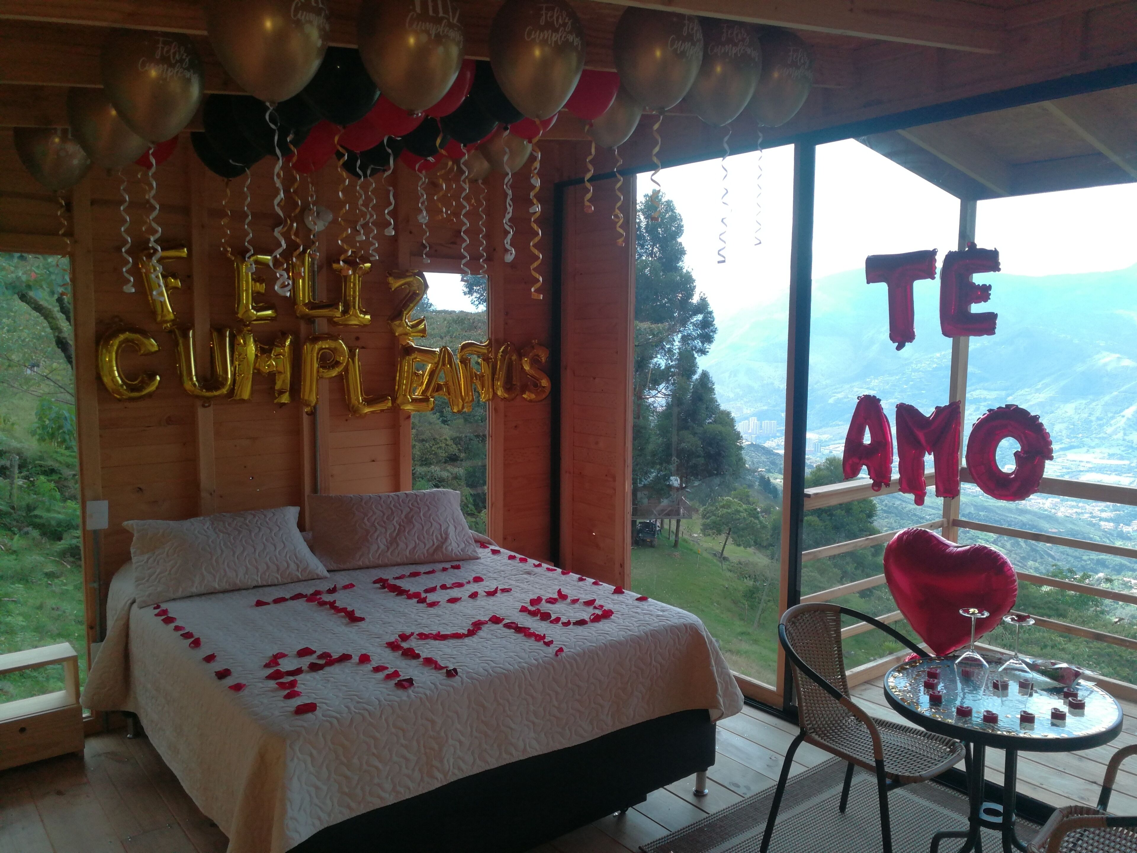Un dormitorio con cama, almohadas y vistas al exterior.