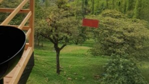 Un balcón de madera con vistas a un paisaje montañoso.