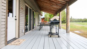 A covered porch with a grill and outdoor seating. - Luxury Cabin,Golf Course,Yellowstone, Stunning Mountain Views,Tubing, Rafting, (Island Park)