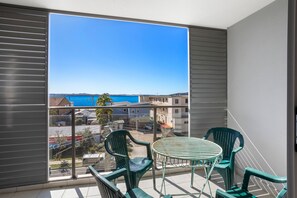 A balcony with a view of the sea and buildings. - The Shoal Apartment 310 Coastal Escape with Views (Shoal Bay)