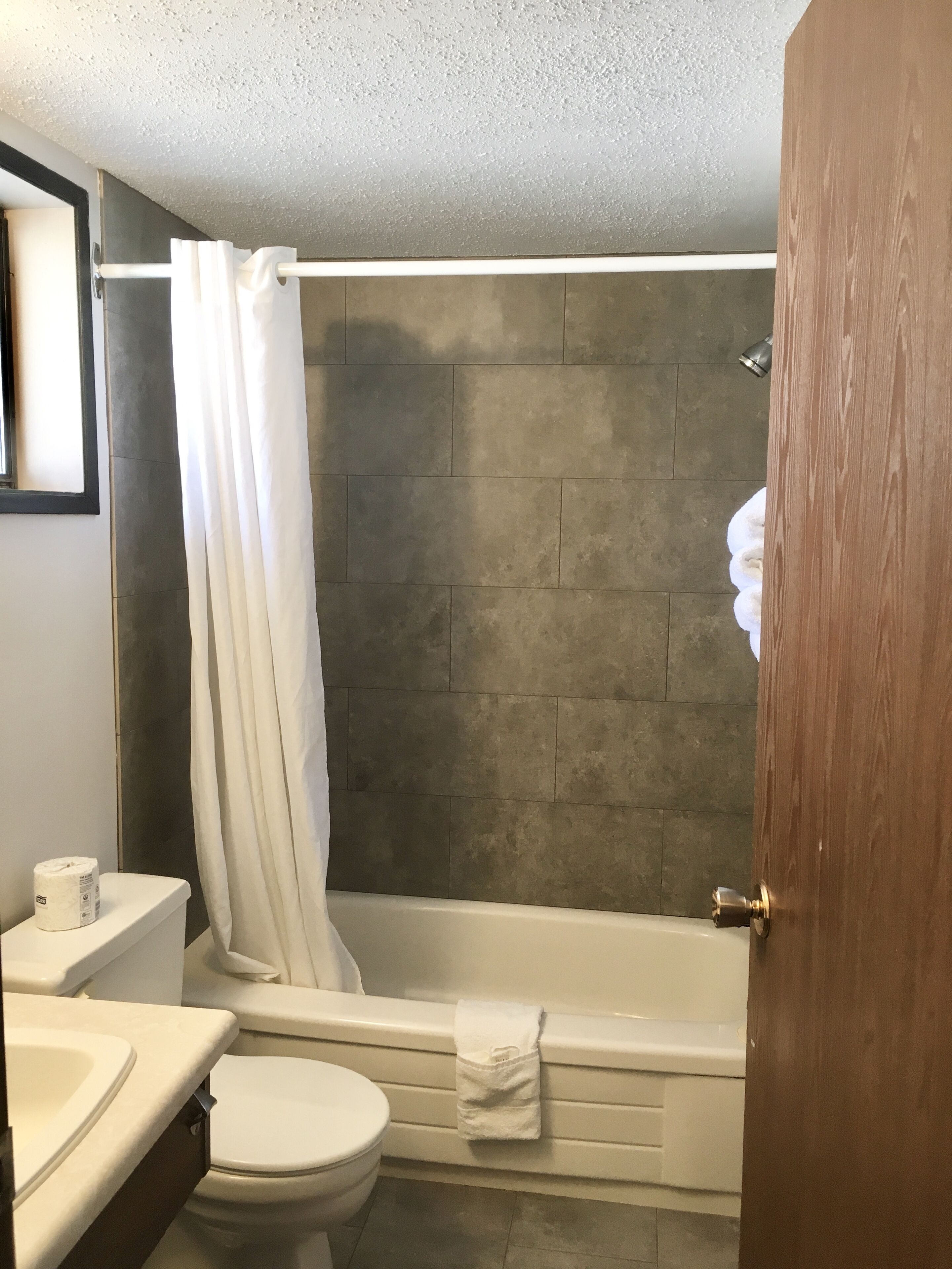 A bathroom with a bathtub, toilet, and sink.