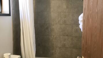 A bathroom with a bathtub, toilet, and sink.
