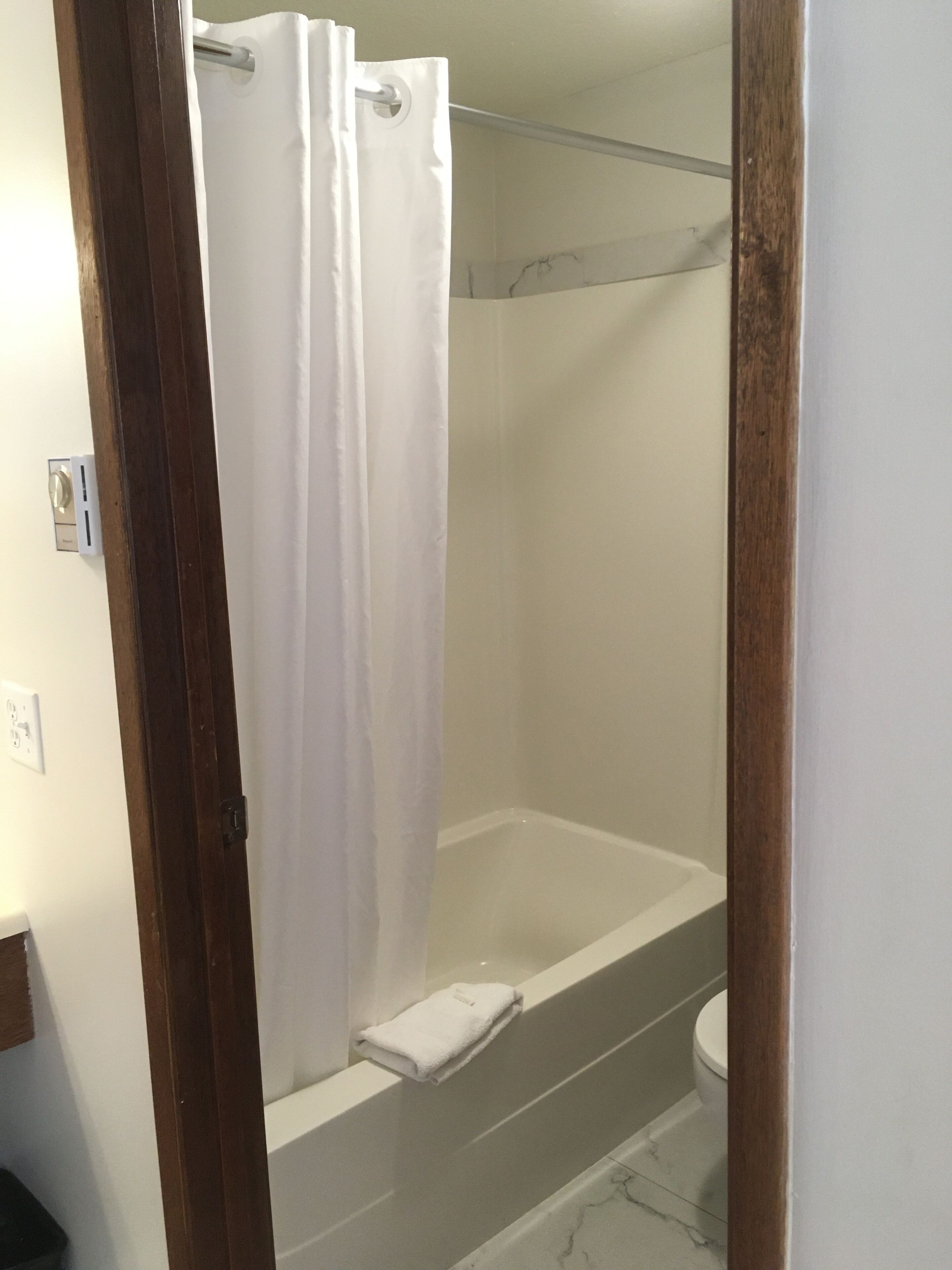 A bathroom with a shower, toilet, and bathtub.
