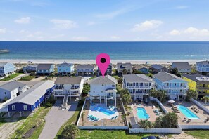 A beachfront hotel with multiple buildings, a swimming pool, and a pier in the background. - 5 Buoys: Ocean View House Near Ocean Crest Pier (Oak Island)