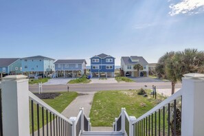 A residential street with houses, a clear sky, and a grassy area. - 5 Buoys: Ocean View House Near Ocean Crest Pier (Oak Island)