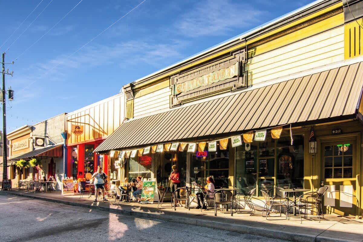 A street with outdoor seating at a restaurant with a yellow awning and a sign that reads 'Culver's'.