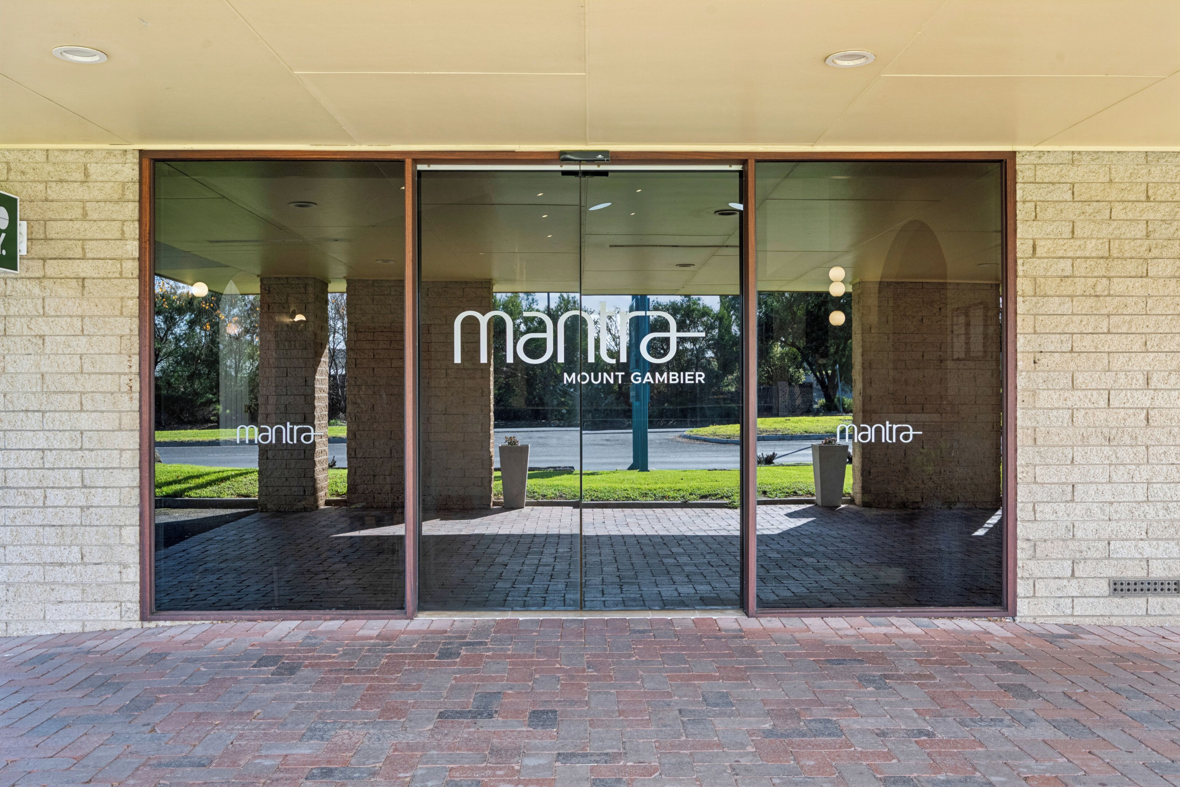 A building entrance with a glass door displaying the name 'mantra' and 'MOUNT GAMBIER' on the glass.