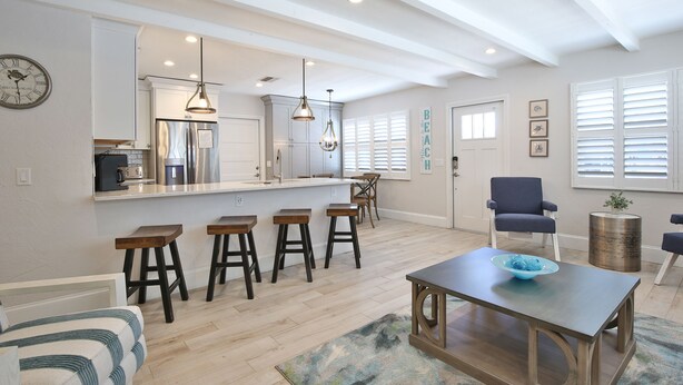 A modern kitchen with a central island, bar stools, and pendant lighting. - 3 bedroom 2 bathroom canal front home with a heated pool located in Anna Maria (Anna Maria Island)