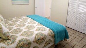 A bedroom with a bed, a door, and a closet. - Delightful, comfortable villa just steps from the beach! (Holmes Beach)