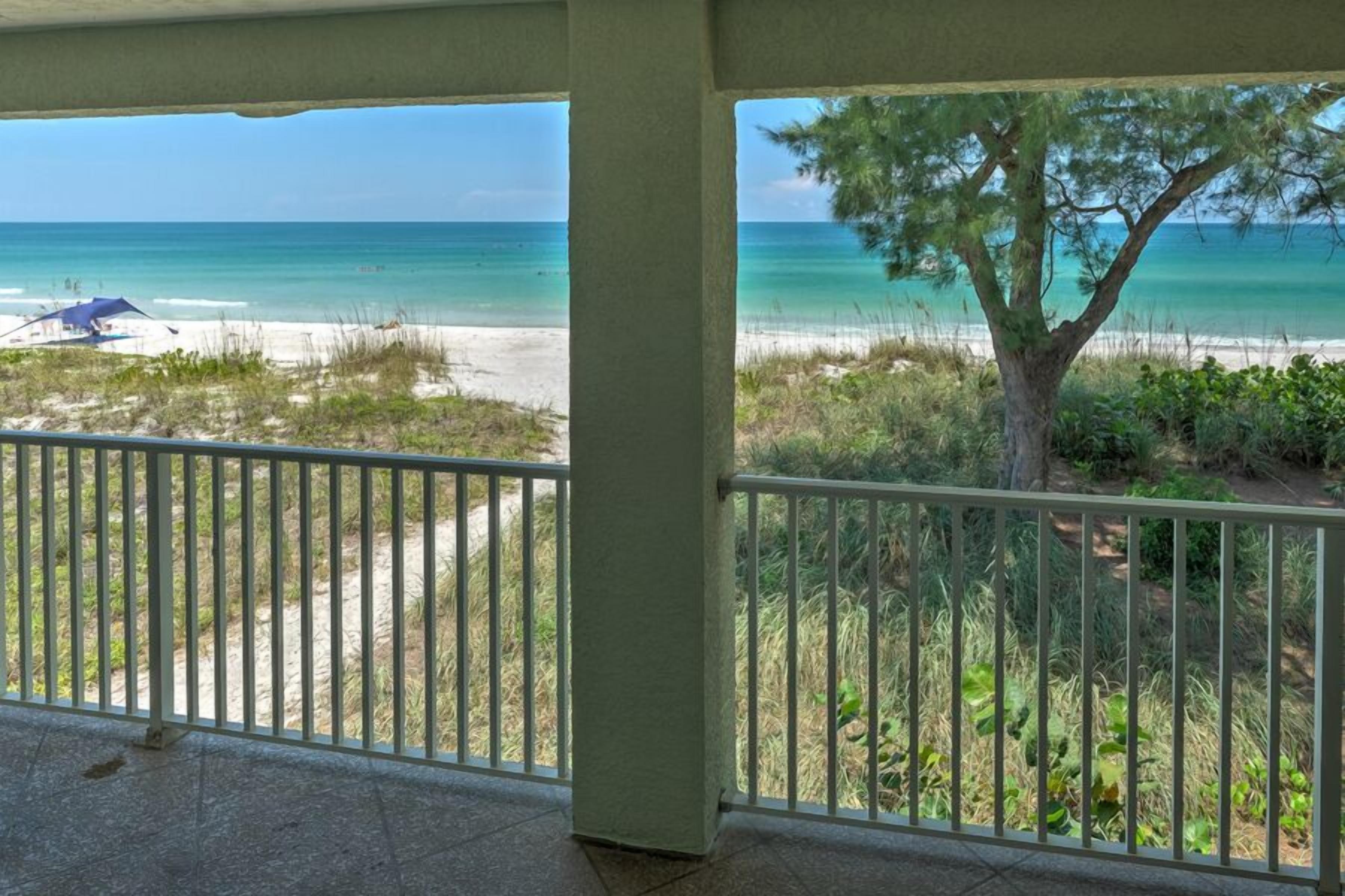 A balcony with a view of a beach and ocean.