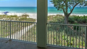 A balcony with a view of a beach and ocean.