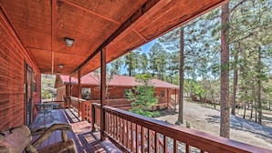 A wooden cabin with a porch, outdoor seating, and a view of surrounding trees. - Wooded Ruidoso Hideaway w/ Deck: Ski, Hike & Golf! (Ruidoso)