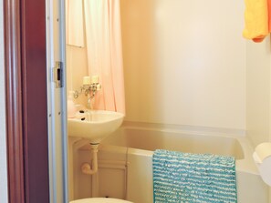 A bathroom with a sink, toilet, and shower curtain. - pension AKA-TOMBO (Shinshiro)