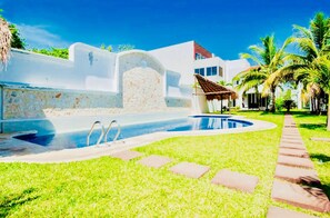 A swimming pool with a stone wall, a small gazebo, and palm trees. - Superior Villa Playacar – 500 m from the Beach & 5th Avenue (Playa del Carmen)