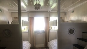 A room with two beds, a small rug, and a staircase. - The Russell Lake House (Winter Haven)