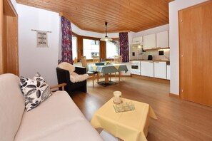 Relax in this inviting living room with a sofa, dining table, and fully equipped kitchen.