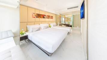 A modern hotel room with a large bed, a sitting area, and a bathroom with a mirror.